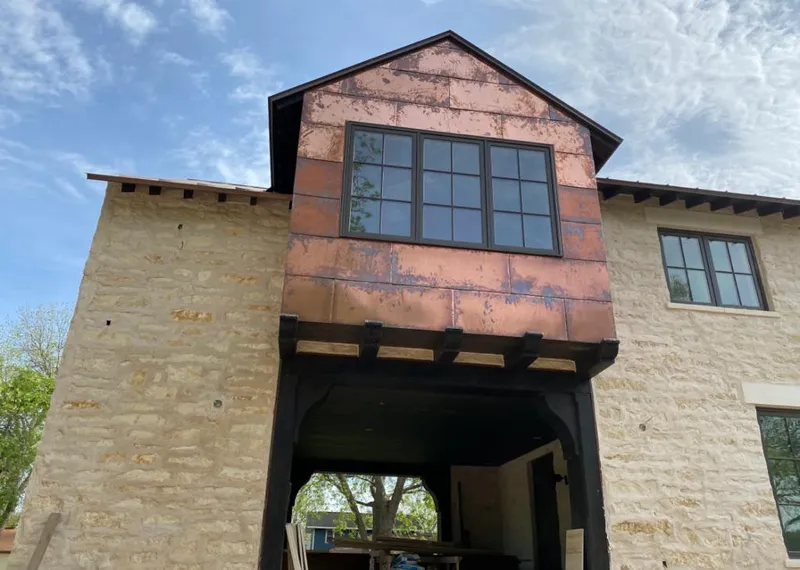 Copper metal panel facade on a stone building for Skylight Installation in De Pere