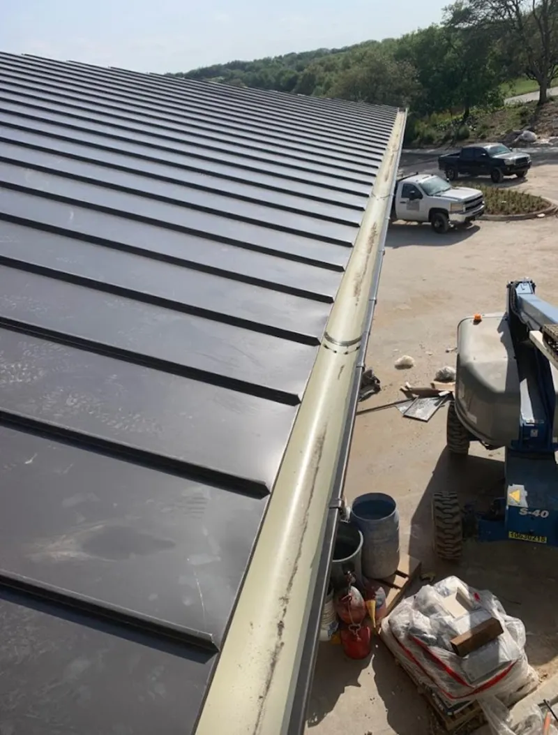 Standing seam panel and gutter detail on a metal roofing jobsite in De Pere